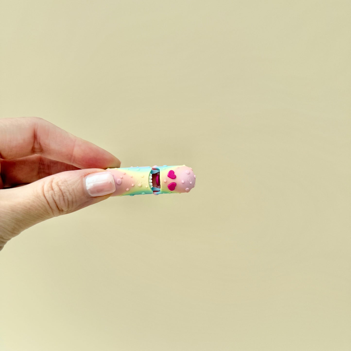 A colourful pickle fidget toy with realistic ridges, heart-shaped eyes, and an opening feature.