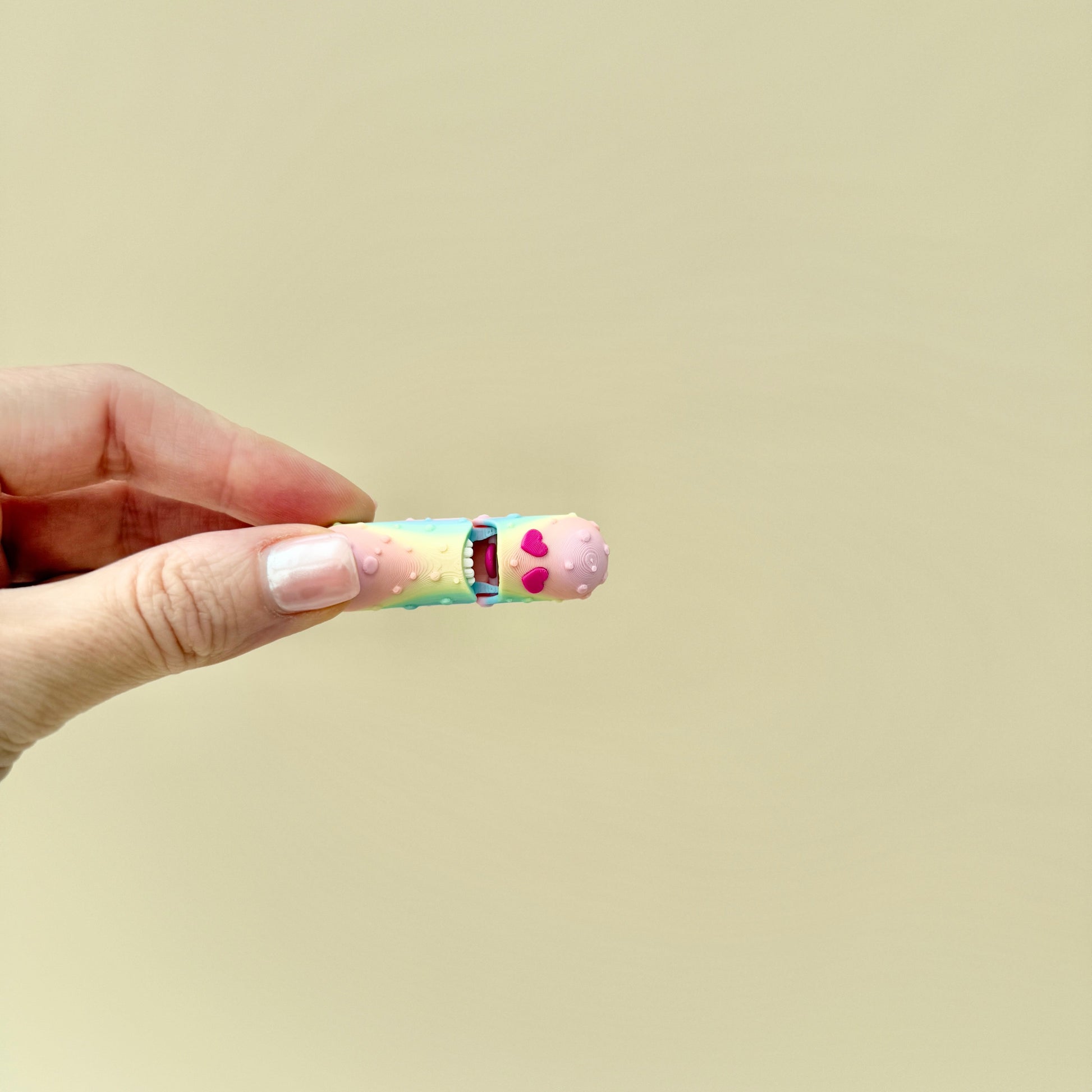 A colourful pickle fidget toy with realistic ridges, heart-shaped eyes, and an opening feature.