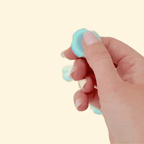 Compact sensory tool with a smooth central surface and ridged outer ring for tactile stimulation.