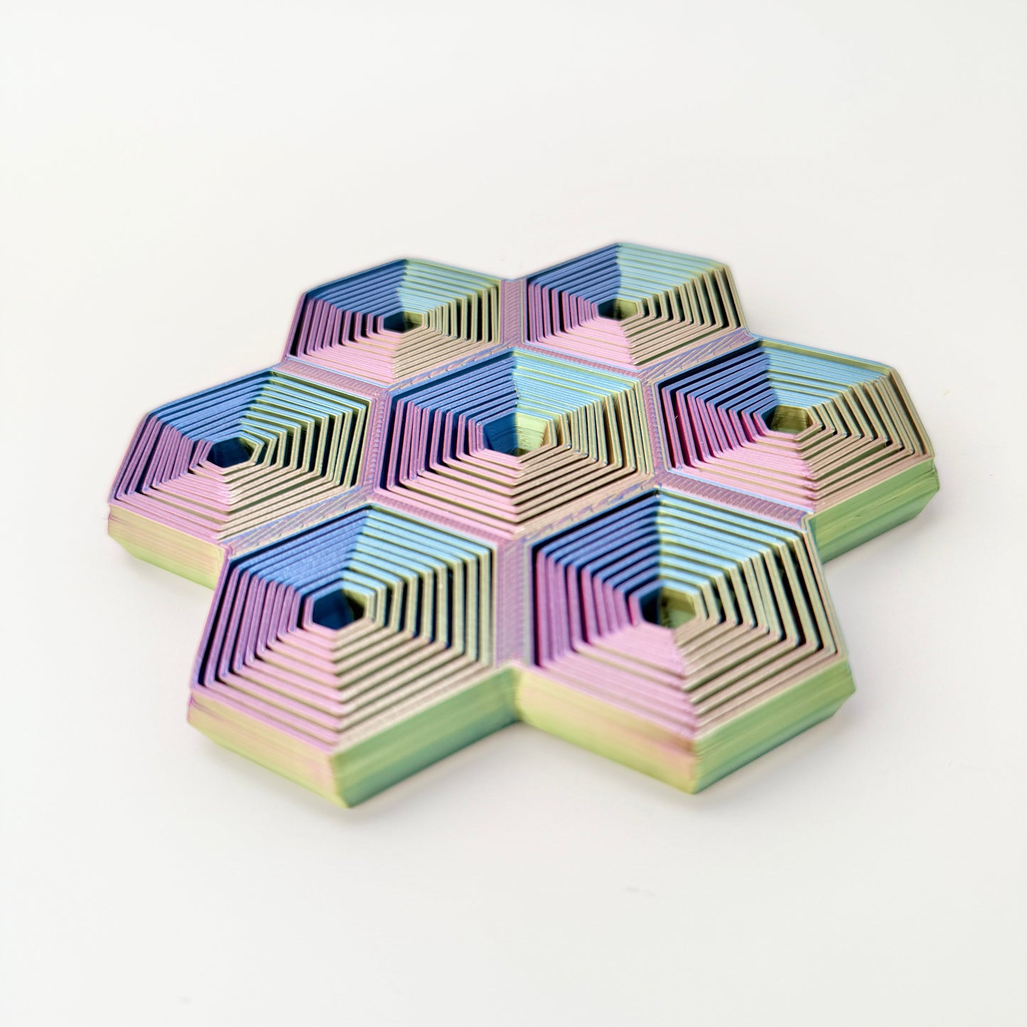 Seven hex cells move independently to create wave-like motion on a flat surface.
