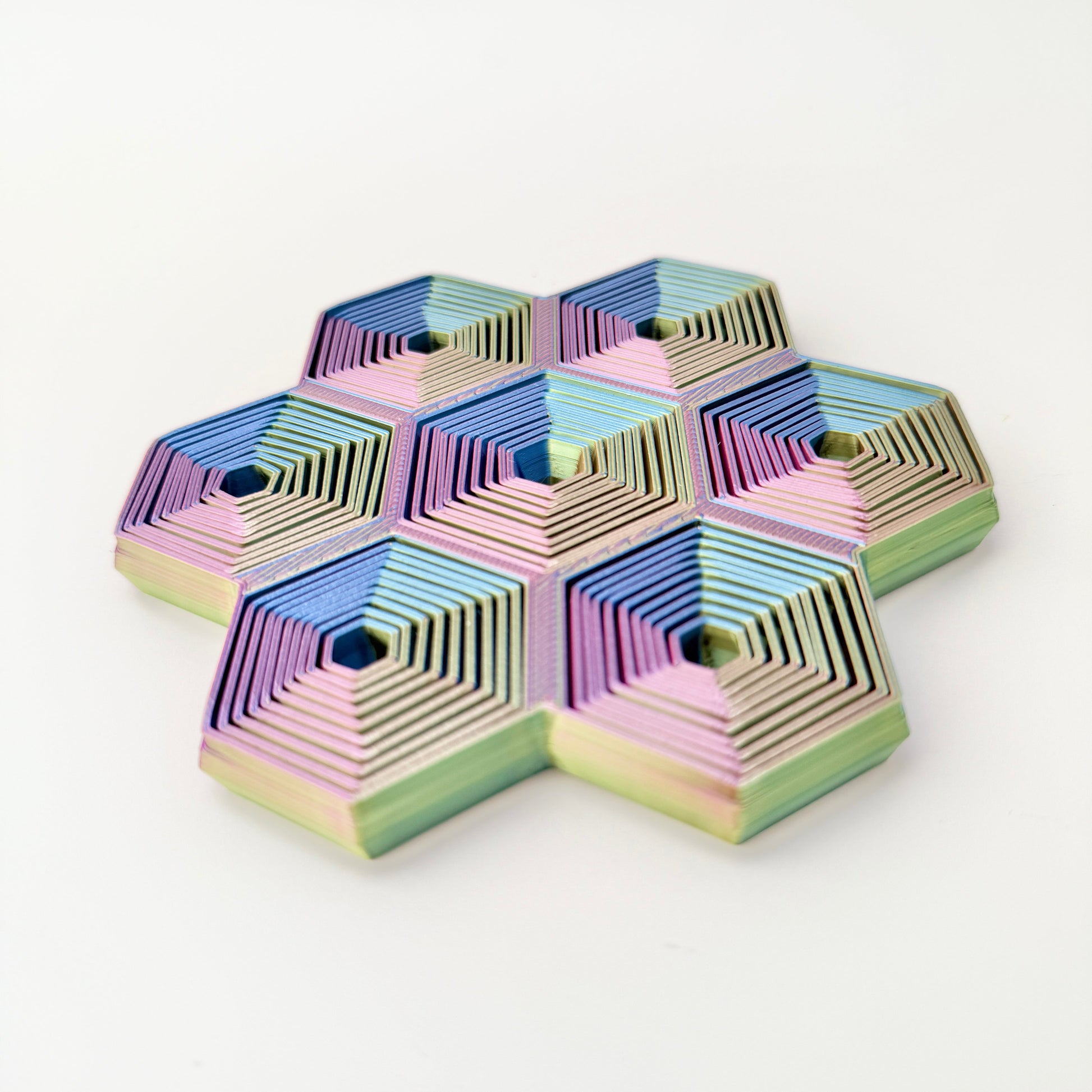 Seven hex cells move independently to create wave-like motion on a flat surface.
