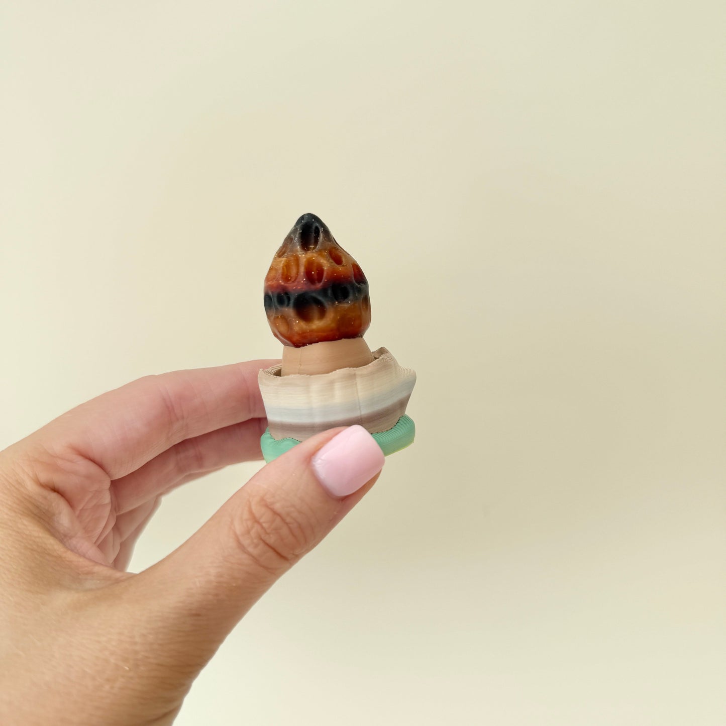 Handheld clicker with sculpted cap and tactile stem.

