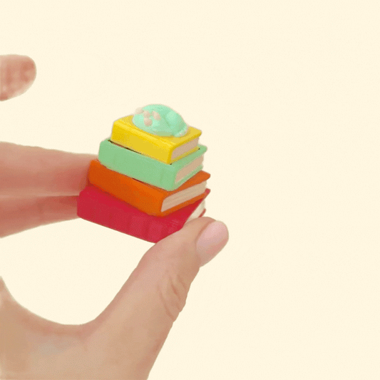 Mini book-stack clicker with a curled dragon on top and a press-to-click action.

