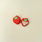 Compact strawberry-shaped clicker with textured detailing for sensory play.
