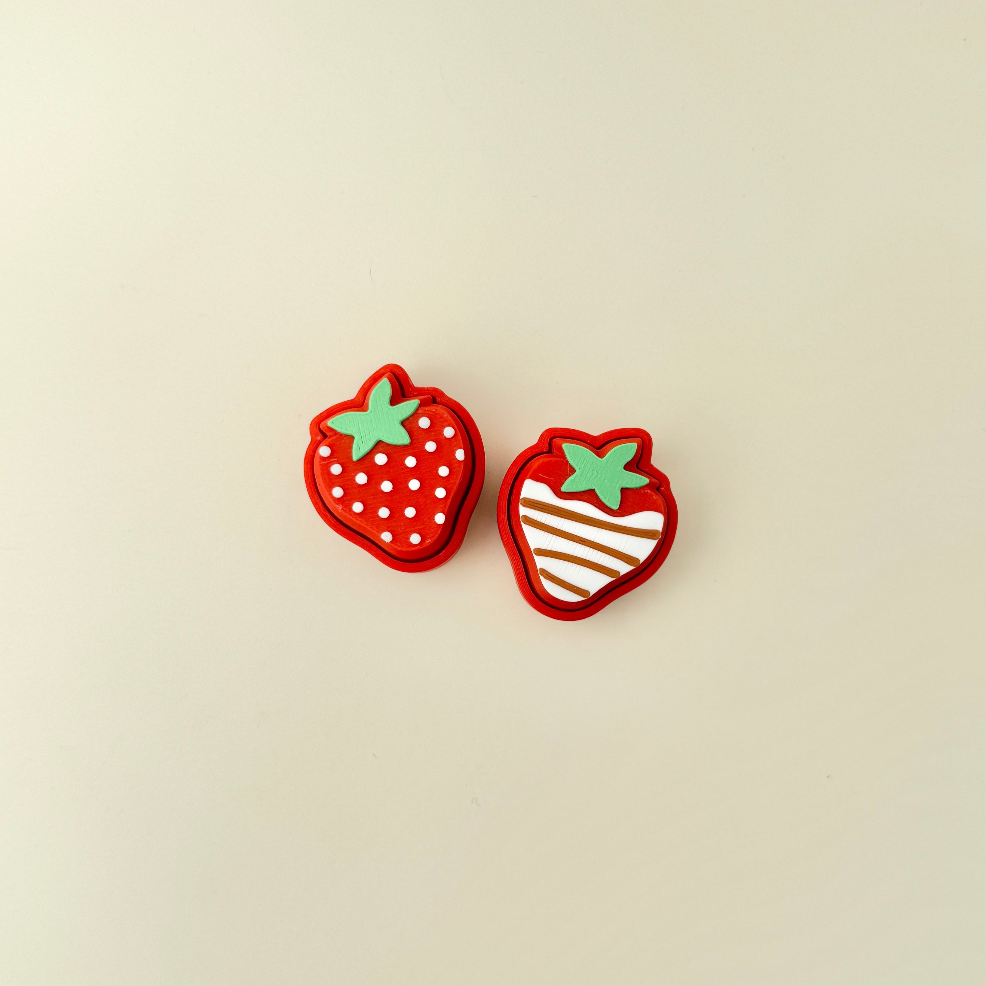 Compact strawberry-shaped clicker with textured detailing for sensory play.
