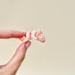 A SoftTone Mini Pet being held in a hand, demonstrating its compact, pocket-sized design for discreet fidgeting.