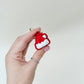 Small seasonal fidget with a firm click; hat shape with textured white “fluff” and keyring loop.
