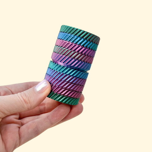 A tall, multi-layered fidget spinner in rainbow colour-changing filament, designed for spinning and twisting.