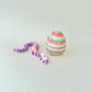 Gradient lilac and peach dragon resting beside a rainbow egg embossed with twinkling stars.