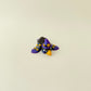 Black, purple and blue gradient bird with raised gold star details.
