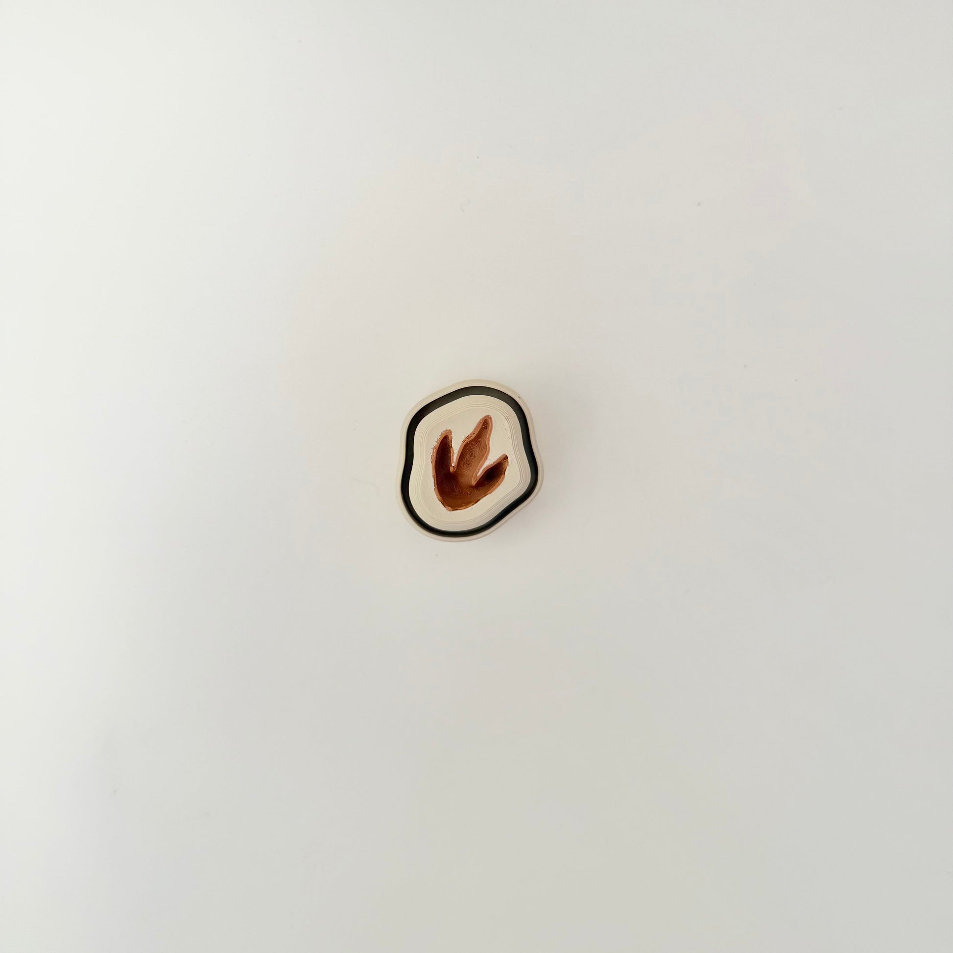 Neutral-tone dinosaur fossil style clicker, 4 cm, press to click, smooth outer edge.
