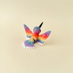 A beautifully detailed hummingbird fidget with white, red, and rainbow accents.