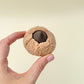 A textured biscuit-style clicker with a press centre designed for tactile sensory input and satisfying clicks.
