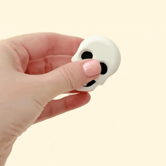 A set of two fidget magnets with a sugar skull design on one side and a realistic skull on the other. Perfect for sensory play and stimming.