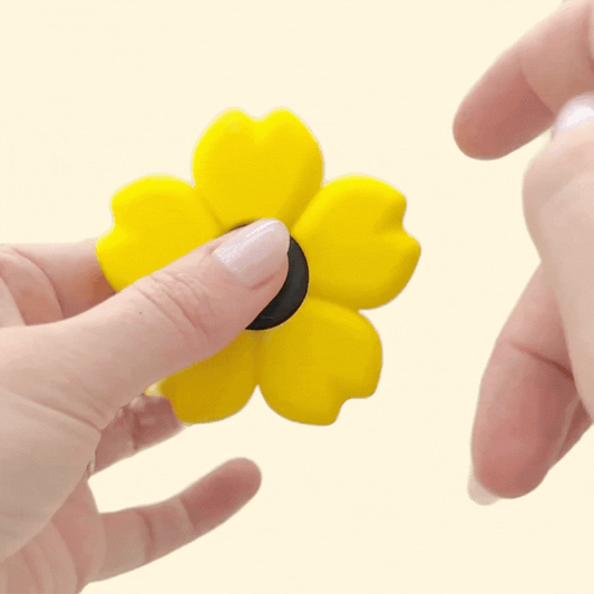 Yellow sunflower-shaped spinner fidget toy with a brown centre for spinning