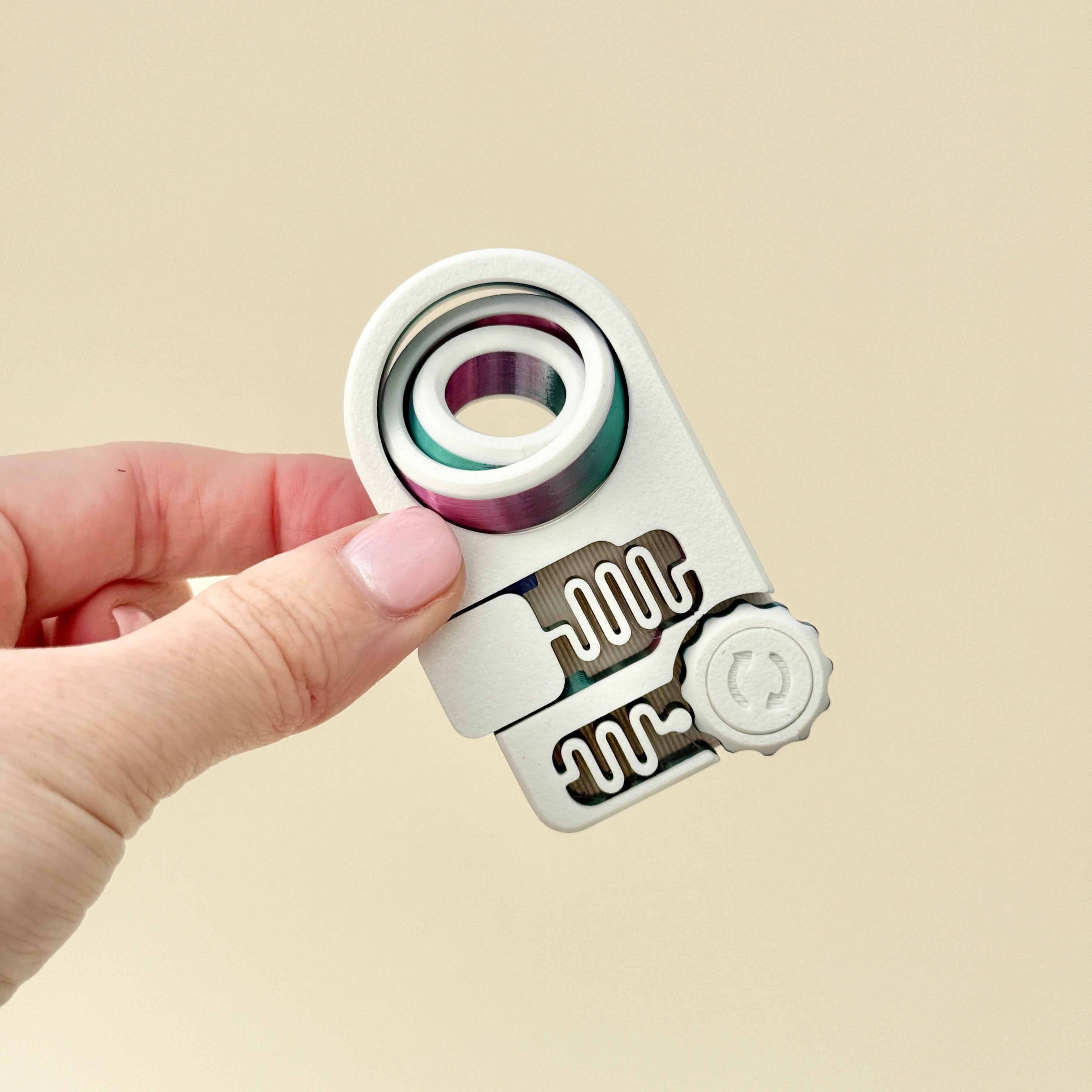 A sleek and flat fidget toy with spinning, clicking, and pressing features for restless hands.
