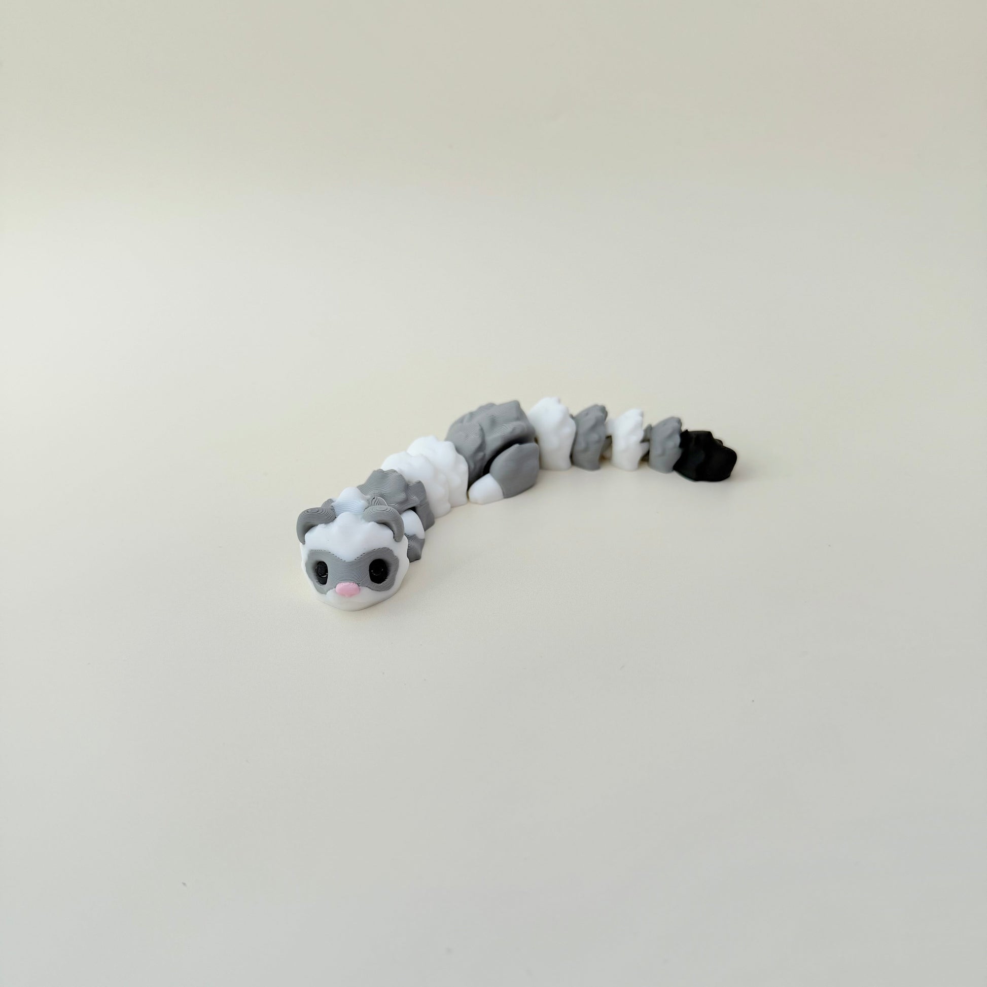 Articulated ferret fidget toy with raised texture for tracing and grounding during focus breaks.
