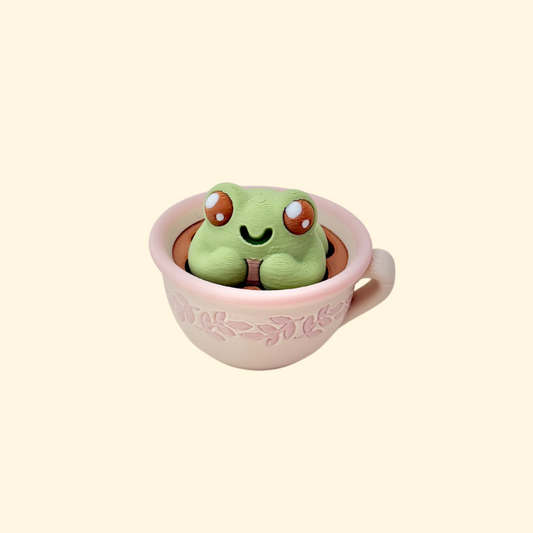 Mini teacup fidget with a pressable frog that clicks for a quick sensory reset.
