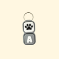 Keychain with paw print and letter 'A' on a beige background