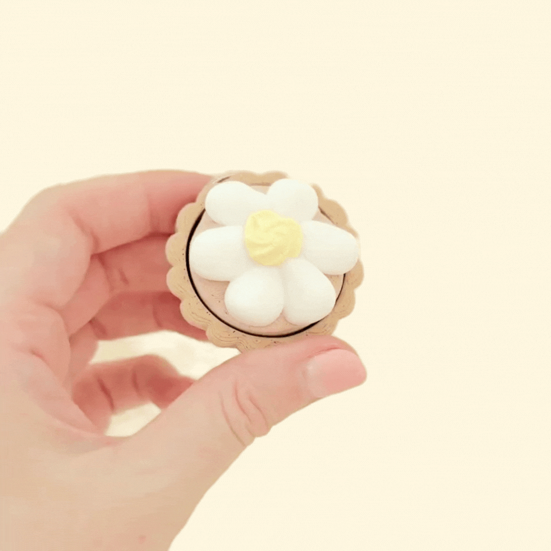 Small tart-shaped sensory toys with pressable tops and detailed toppings.