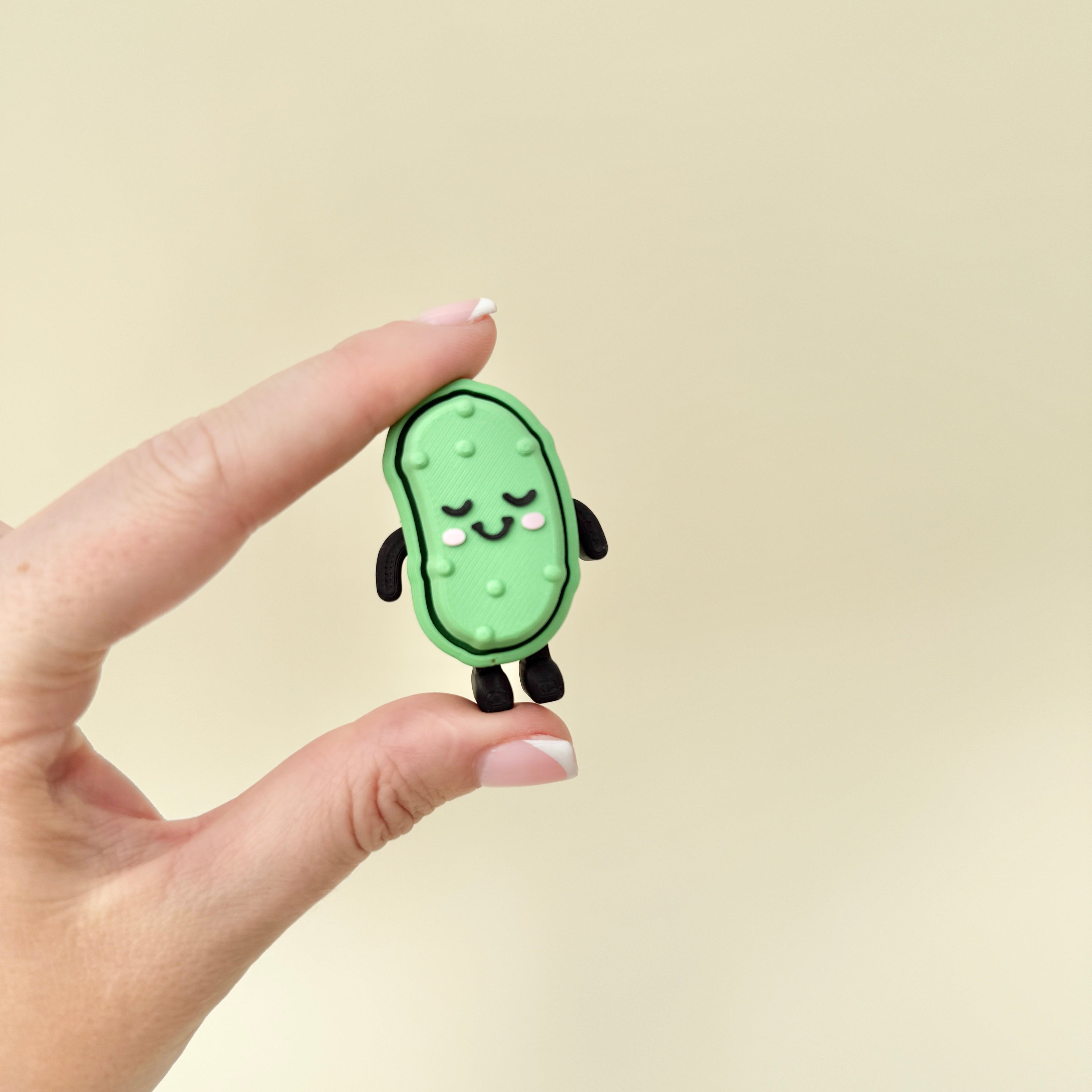 Green fidget toy with raised details and keychain loop, designed for tactile and click-based stimming.