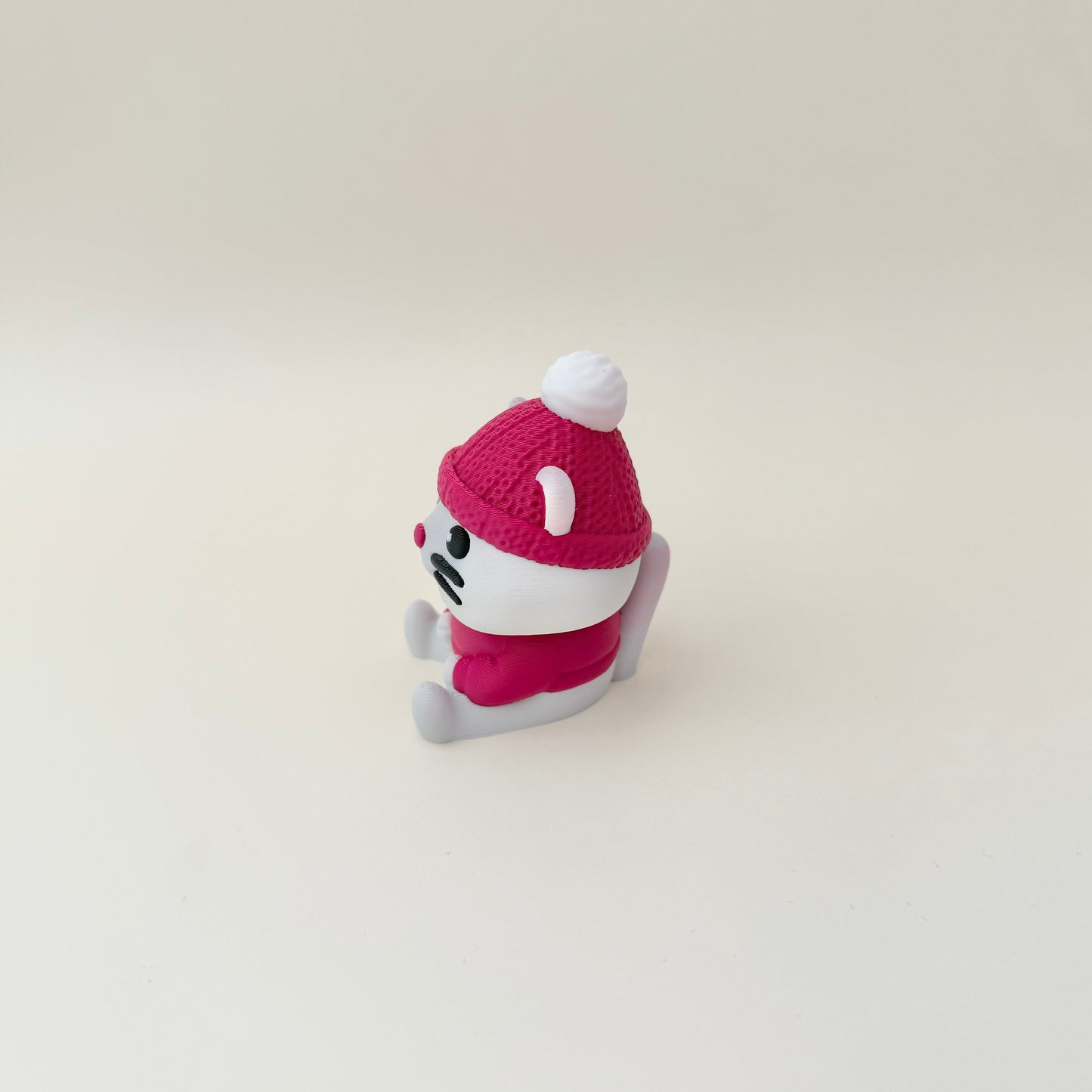 Cat clicker with ribbed hat, jumper detail and smooth face for thumb tracing and grounding.
