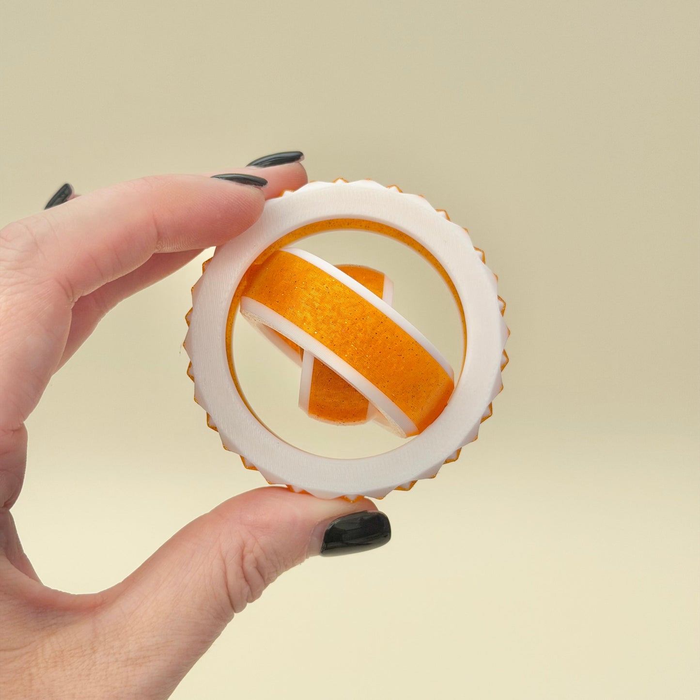 White and gold sensory spinner with ridged edge for tactile feedback and calm.
