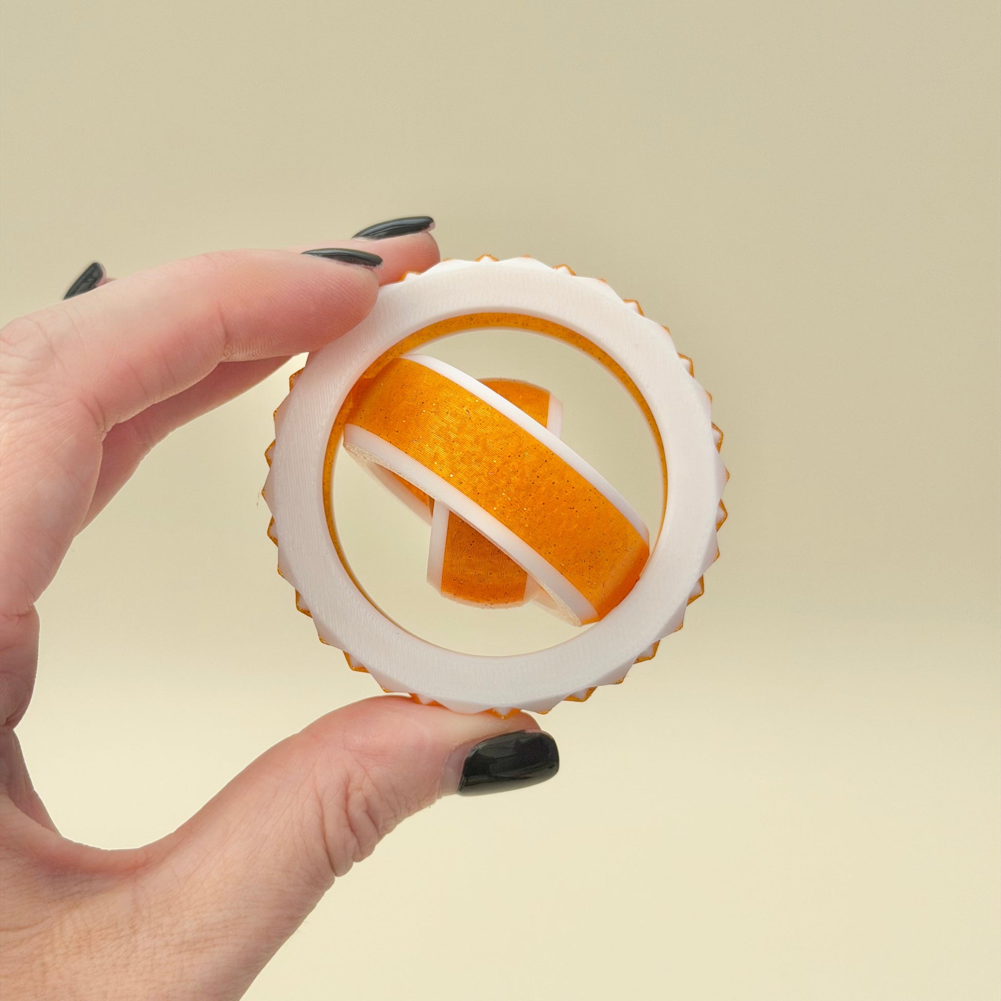 White and gold sensory spinner with ridged edge for tactile feedback and calm.
