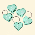 Mint green heart-shaped fidget clicker with “They/Them” pronouns, attached to a keyring.