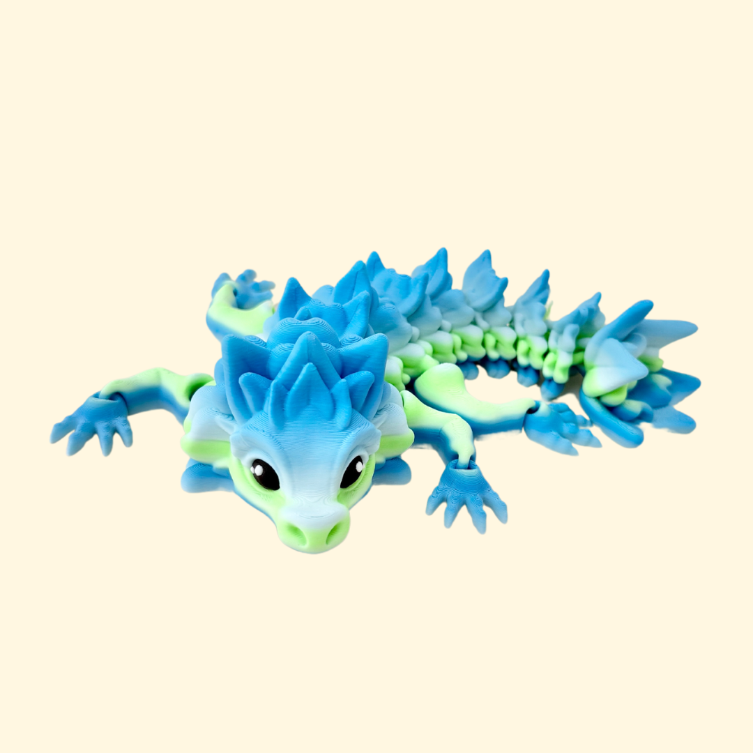 Chunky dragon fidget toy with a green and blue gradient body, flexible legs, and black and white eyes.
