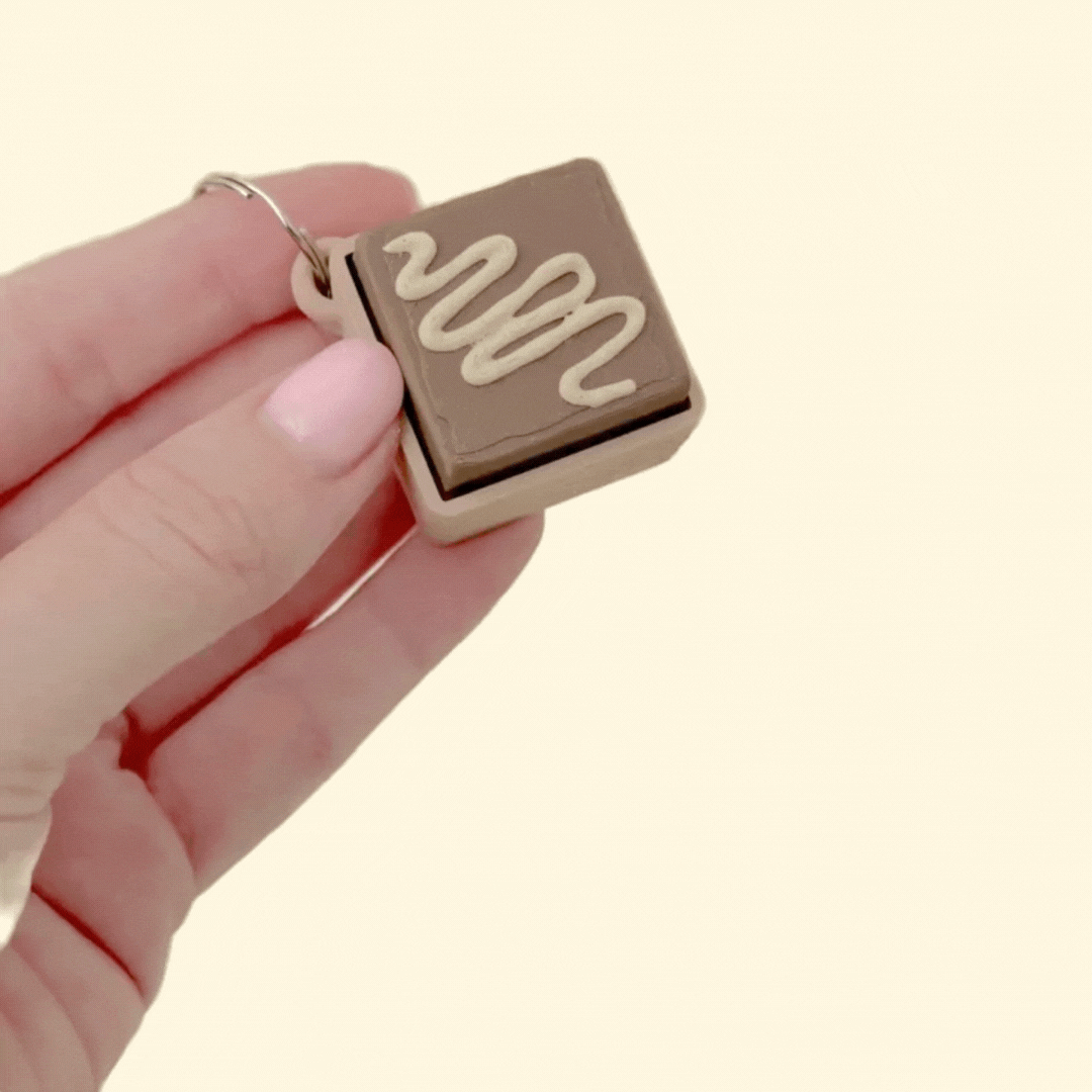Small 3D printed fudge-style fidget clicker with tactile press and keyring loop hole for customer attachment.
