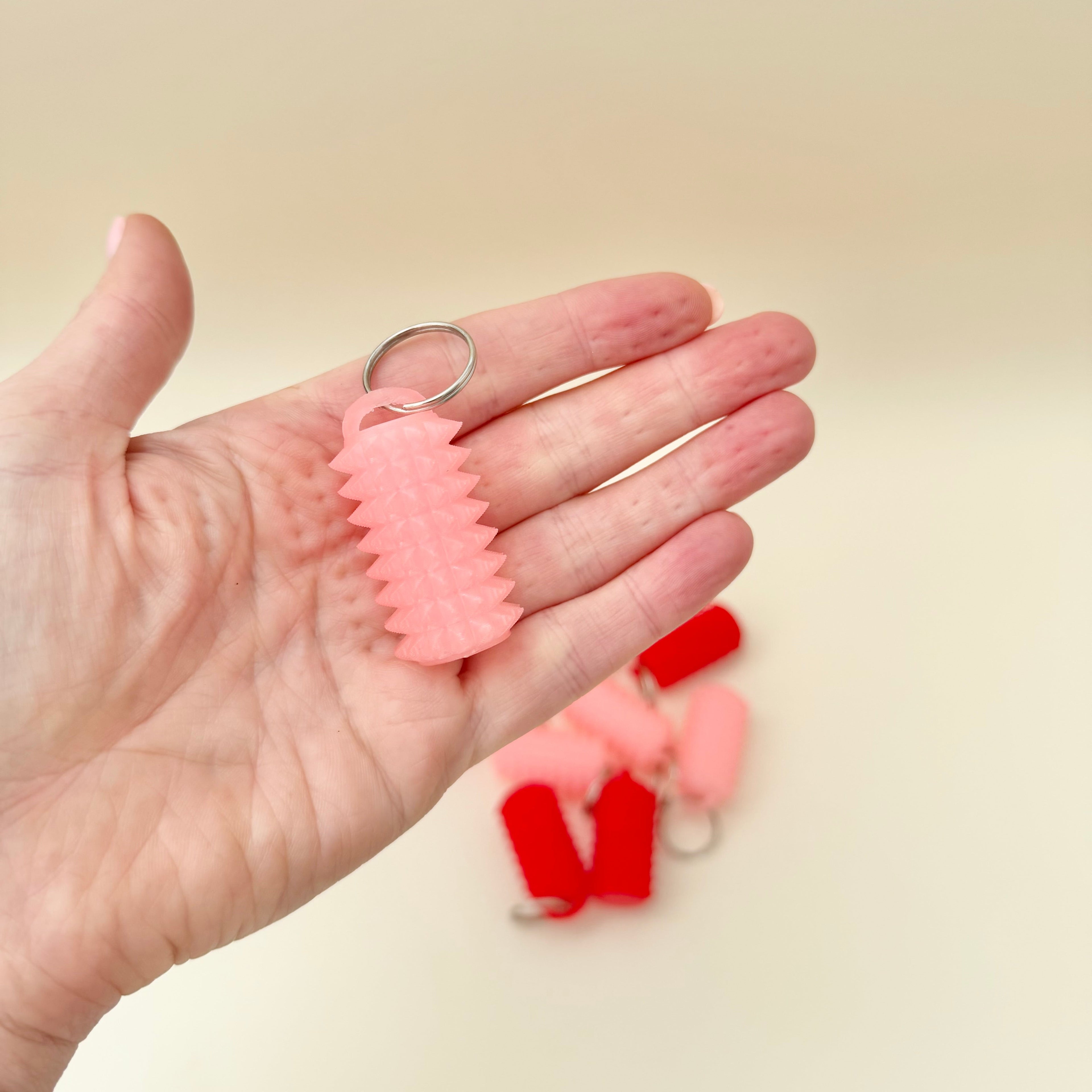 Textured sensory fidget with firm spikes and silver loop for everyday carry.
