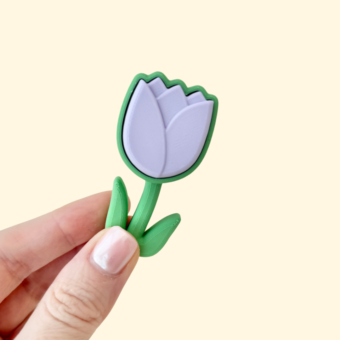 Lilac tulip-shaped fidget clicker toy with a green base, perfect for sensory play and stress relief.