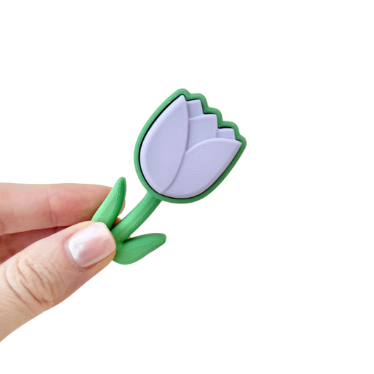 Lilac tulip-shaped fidget clicker toy with a green base, perfect for sensory play and stress relief.