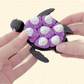 handheld sensory clicker with articulated turtle shape and pop tiles

