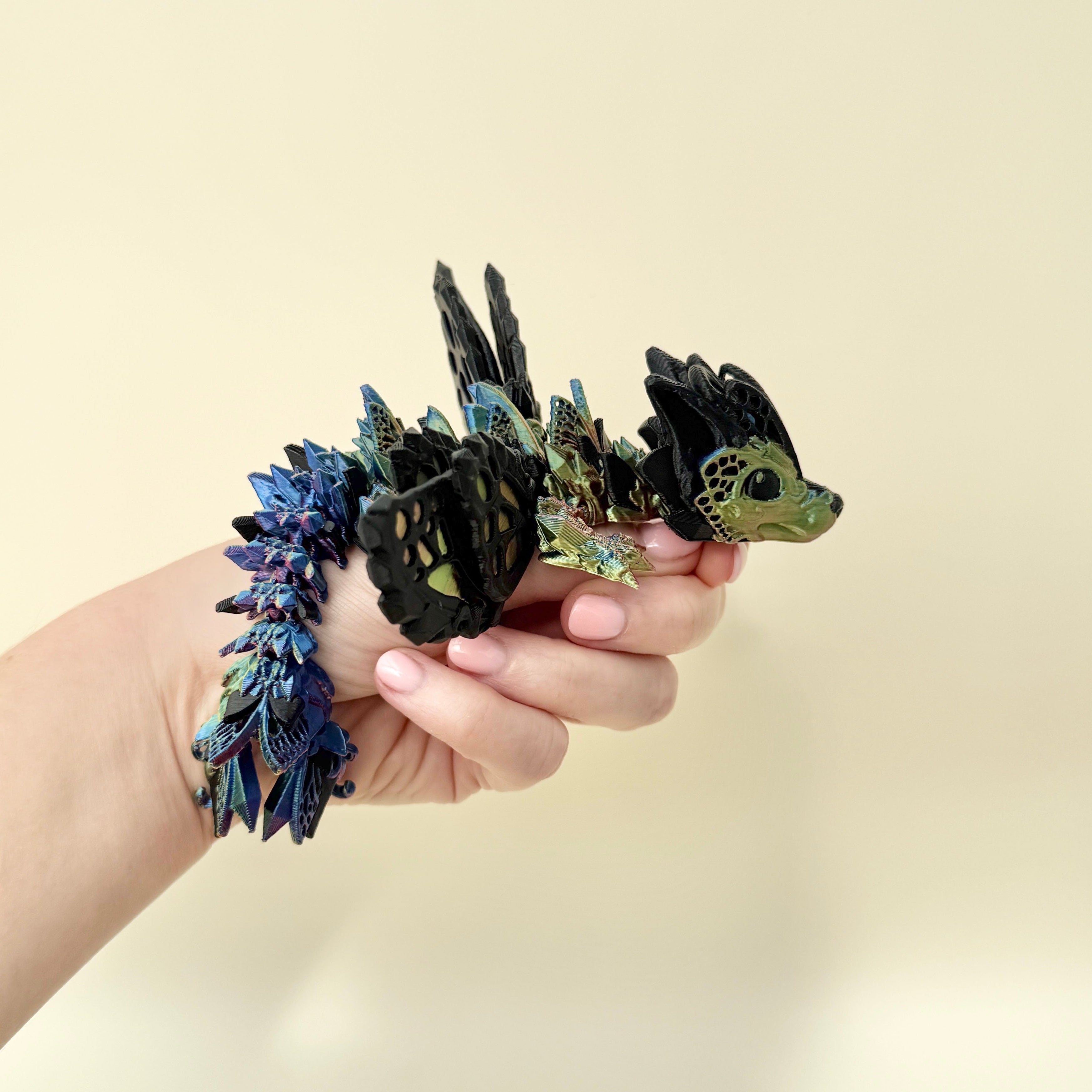 Fantasy-inspired dragon fidget toy featuring a black base and shimmering wings