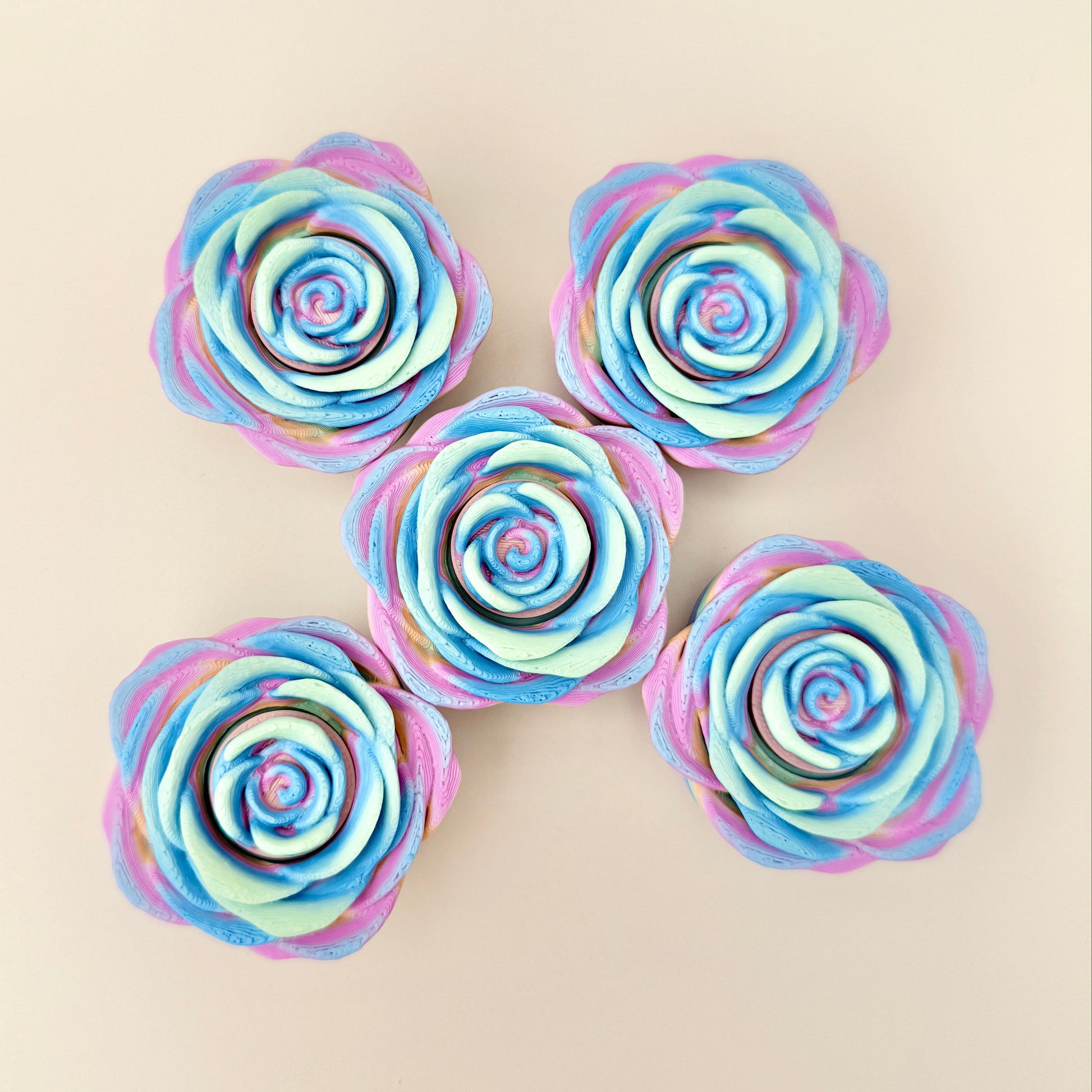 A unique fidget spinner in a rose shape with vibrant rainbow tones.