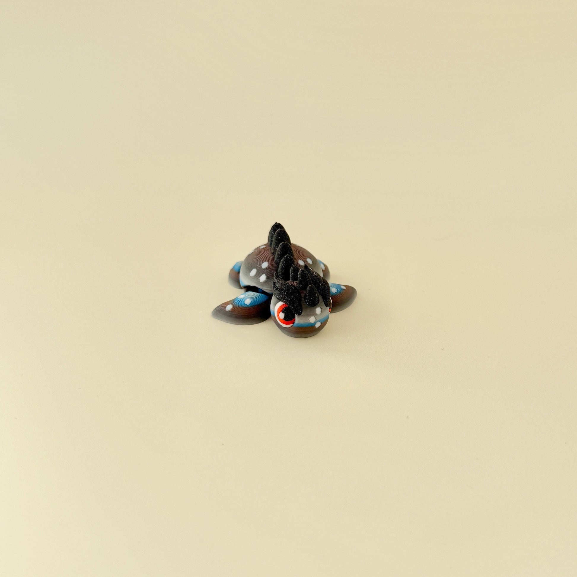 A tactile fidget toy featuring gradient colours in grey, white, brown, and blue with a bold, spiked design.