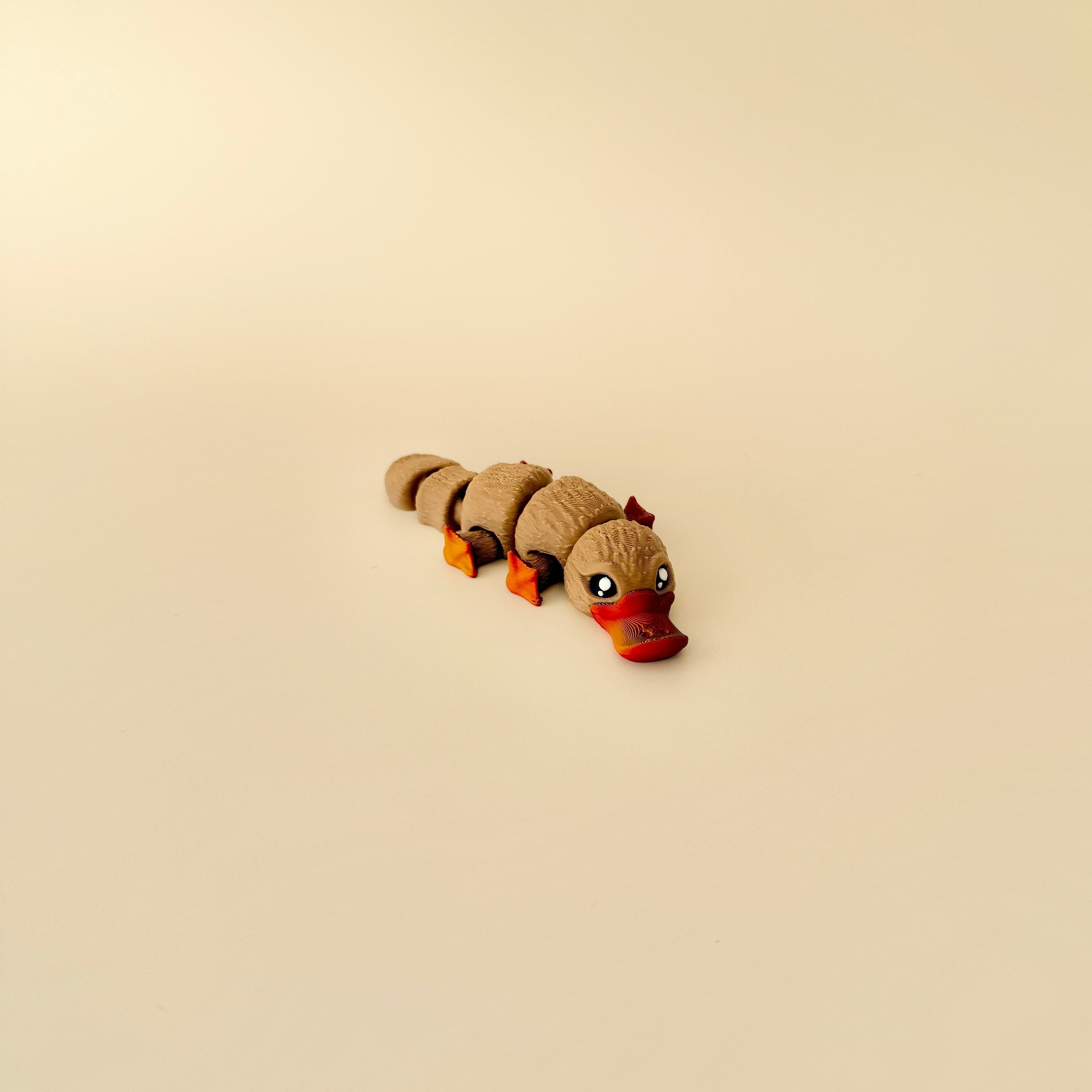 Fully articulated platypus fidget toy with detailed textures, shimmering beak and feet, and realistic design.