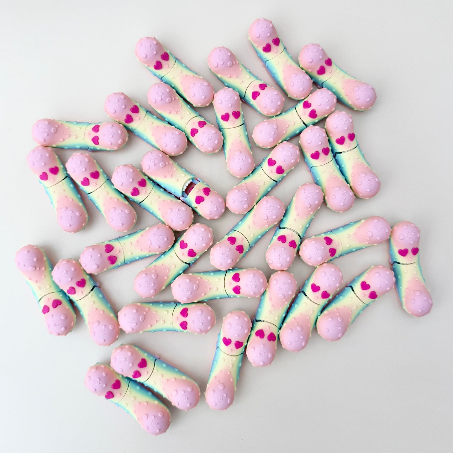 A shimmering rainbow fidget pickle with heart eyes, designed as a playful Valentine’s gift.