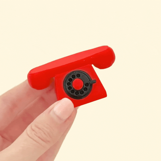 nostalgic telephone shaped stim toy with textured rotary dial details
