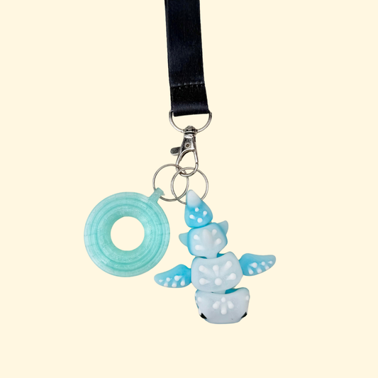 Wearable fidget charm with articulated movement and tactile dot details, designed to clip onto lanyards and keyrings.
