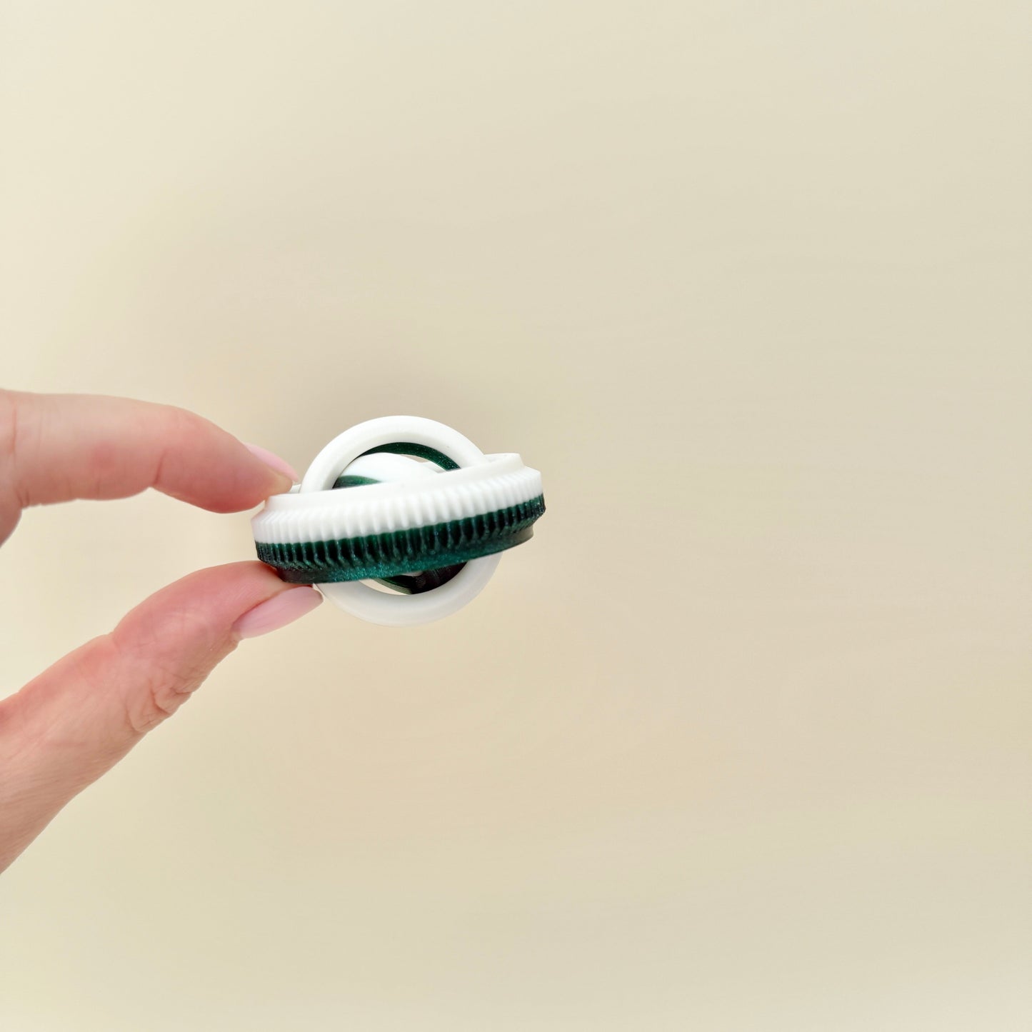 Compact spinner printed in white and sparkly dark green for everyday carry.
