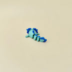 Aquatic-style stim toy with textured body, flexible tail, and shimmering surface details.