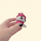 Grey cat toy in plum knit outfit for tactile stimming and two-hand clicking.
