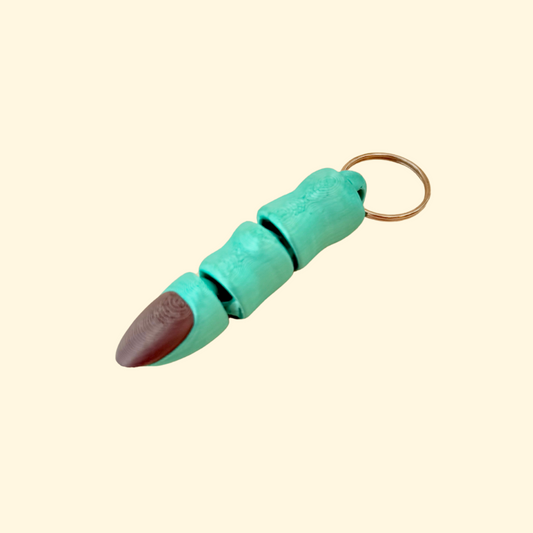 Green finger charm with long black nail on keyring attachment
