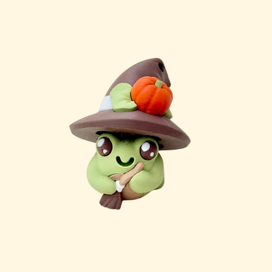 Mini frog with hat and broom plus a loop for attaching to keys or lanyards.
