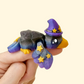 Sparkly midnight crow with a small hat and curled wings for quiet fidgeting.
