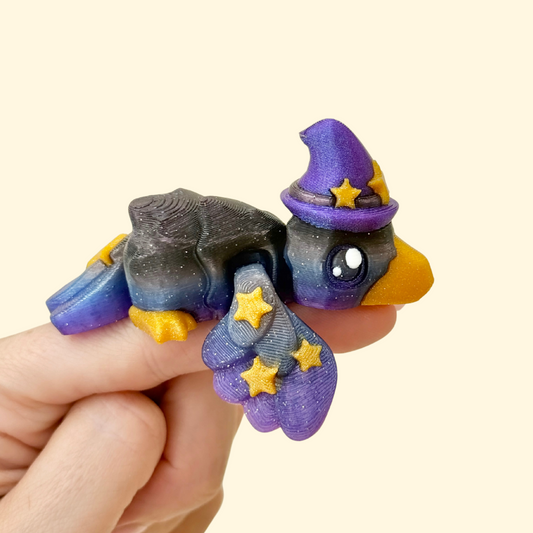 Sparkly midnight crow with a small hat and curled wings for quiet fidgeting.
