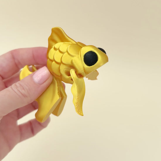 Elegant silk gold goldfish fidget toy featuring scale texture and moveable fins and tail.